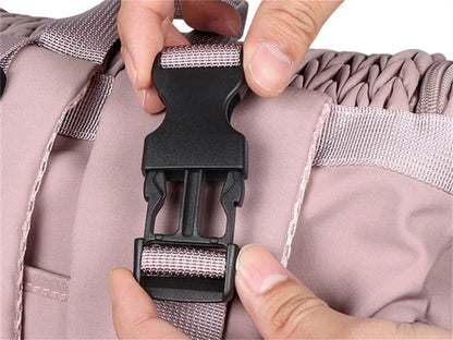 Gros plan sur la boucle a clip du sac a langer rose qui se ferme et s'ouvre facilement d'une seule main.