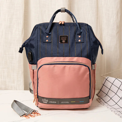 Version bleu marine et rose du sac a langer avec port USB integre, pour recharger son telephone en promenade.