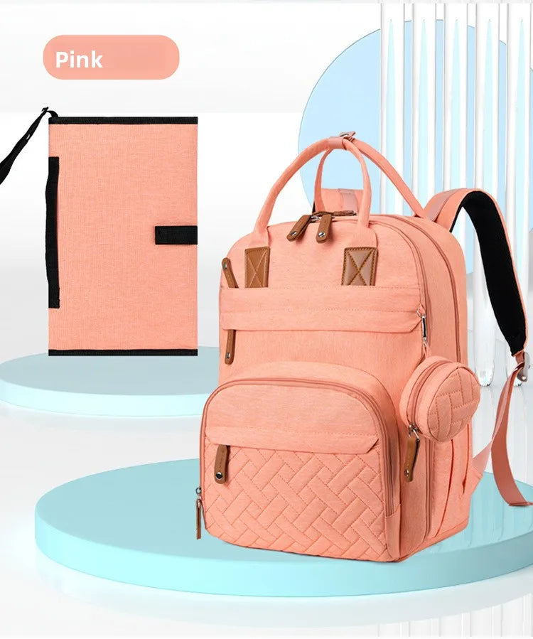 Sac a langer rose poudre presente avec sa pochette a tetine assortie, un ensemble complet au design elegant pour jeunes parents.