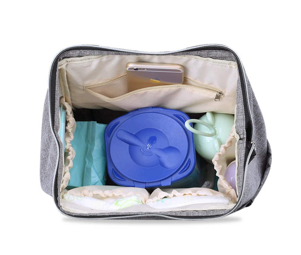 Interieur du sac a langer avec poches separees et compartiment zippe pour ranger le telephone et garder chaque accessoire a sa place.