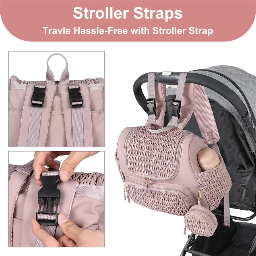 Demonstration de la fixation du sac a langer rose sur le guidon d'une poussette grace aux boucles ajustables incluses.
