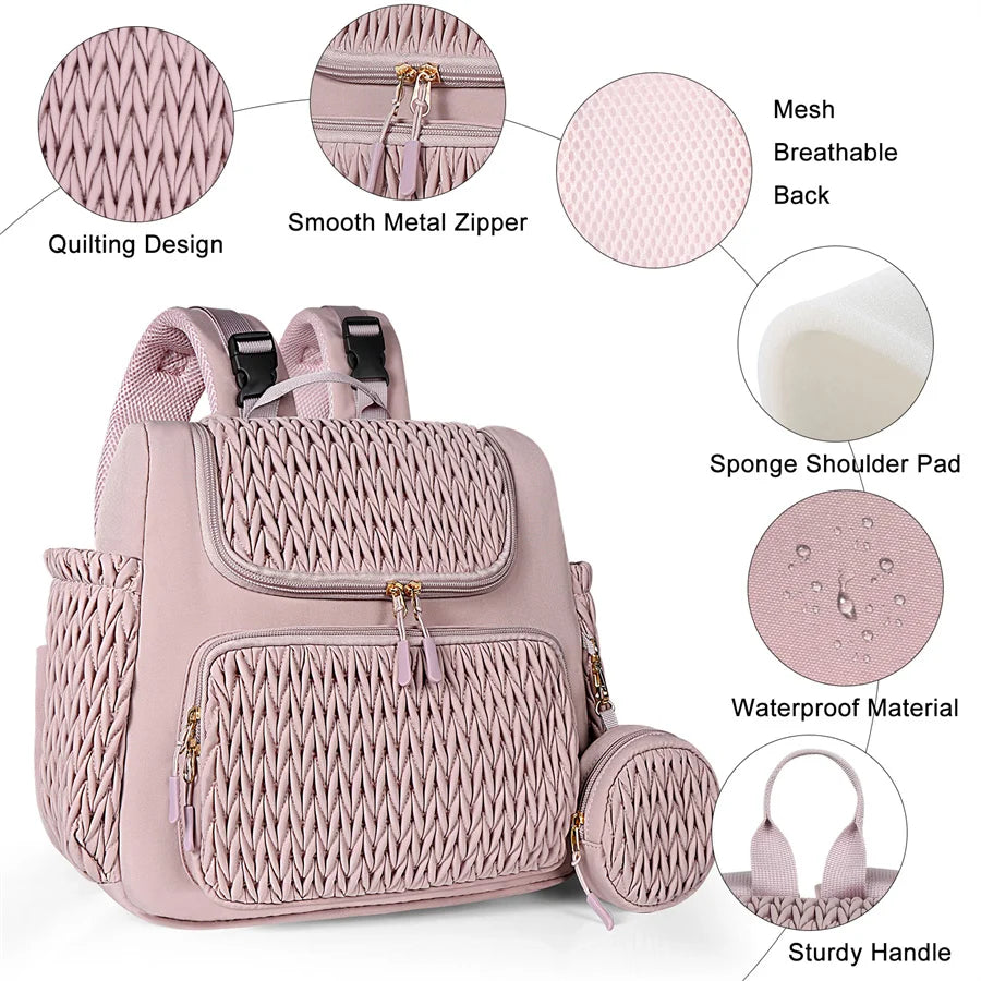 Details des finitions du sac a langer rose avec surpiqure matelassee, fermetures metalliques et dos en mesh respirant confortable.
