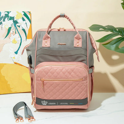 Sac a langer rose et gris au design elegant matelasse, presente en ambiance avec ses sangles de fixation pour poussette.