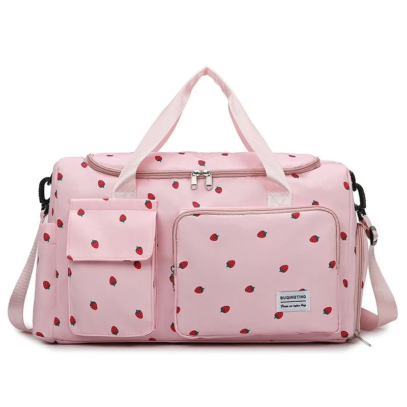Sac a langer rose a motif fraises avec poches frontales, poignees renforcees et bandouliere amovible pour les parents nomades.