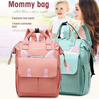 Maman souriante avec son bebe portant le sac a langer disponible en rose et vert menthe pour les sorties du quotidien