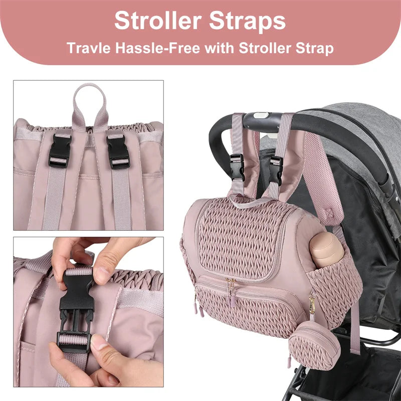 Sac a langer rose fixe sur une poussette grace a ses sangles a clips, pour se deplacer les mains libres en promenade.