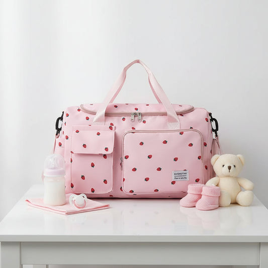 Sac a langer rose a motif fraises avec poches frontales, poignees renforcees et bandouliere amovible pour les parents nomades.