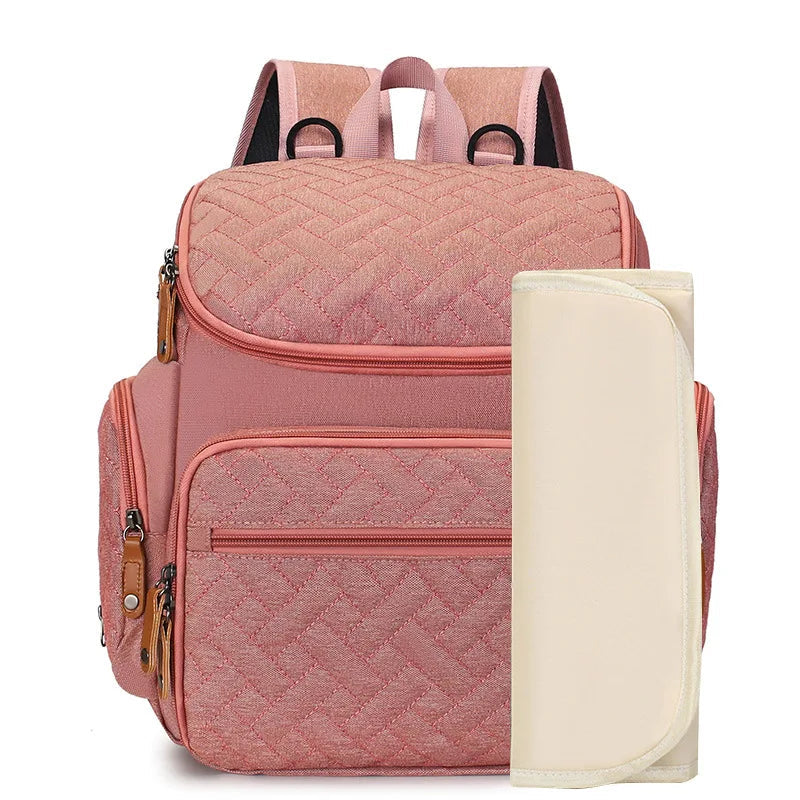 Sac a dos a langer rose poudre au style feminin et delicat, livre avec son tapis a langer assorti.