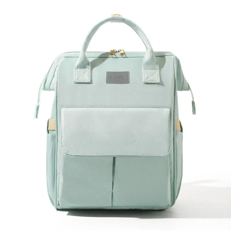 Sac a dos a langer en coloris vert menthe pastel, design elegant et discret pour les sorties avec bebe.