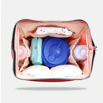 Interieur du sac avec compartiments separes gardant couches, boite a lingettes et biberons parfaitement organises.