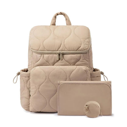 Sac a langer sac a dos matelasse beige livre avec son tapis a langer et sa pochette a tetine assortis pour tout avoir a portee de main.