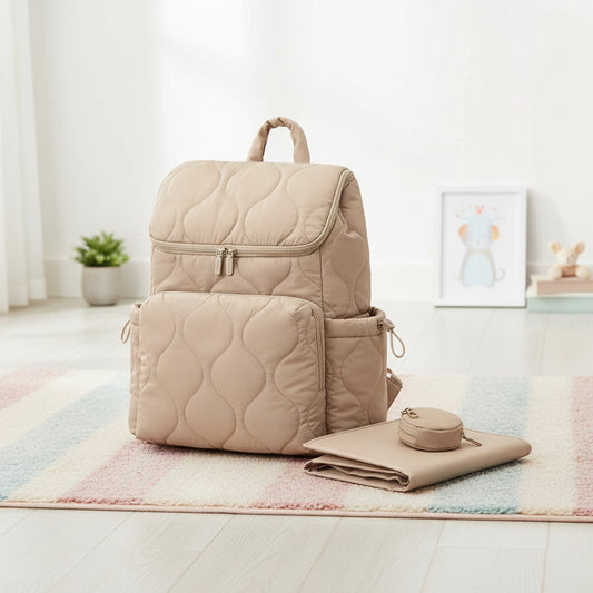 Sac a langer sac a dos matelasse beige livre avec son tapis a langer et sa pochette a tetine assortis pour tout avoir a portee de main.