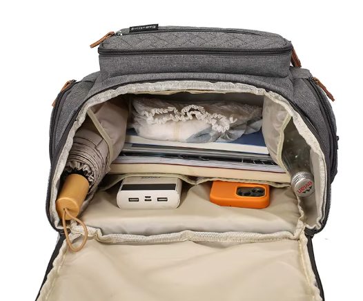 Interieur spacieux du sac a langer revelant de multiples compartiments pour organiser couches, biberons et affaires de bebe.