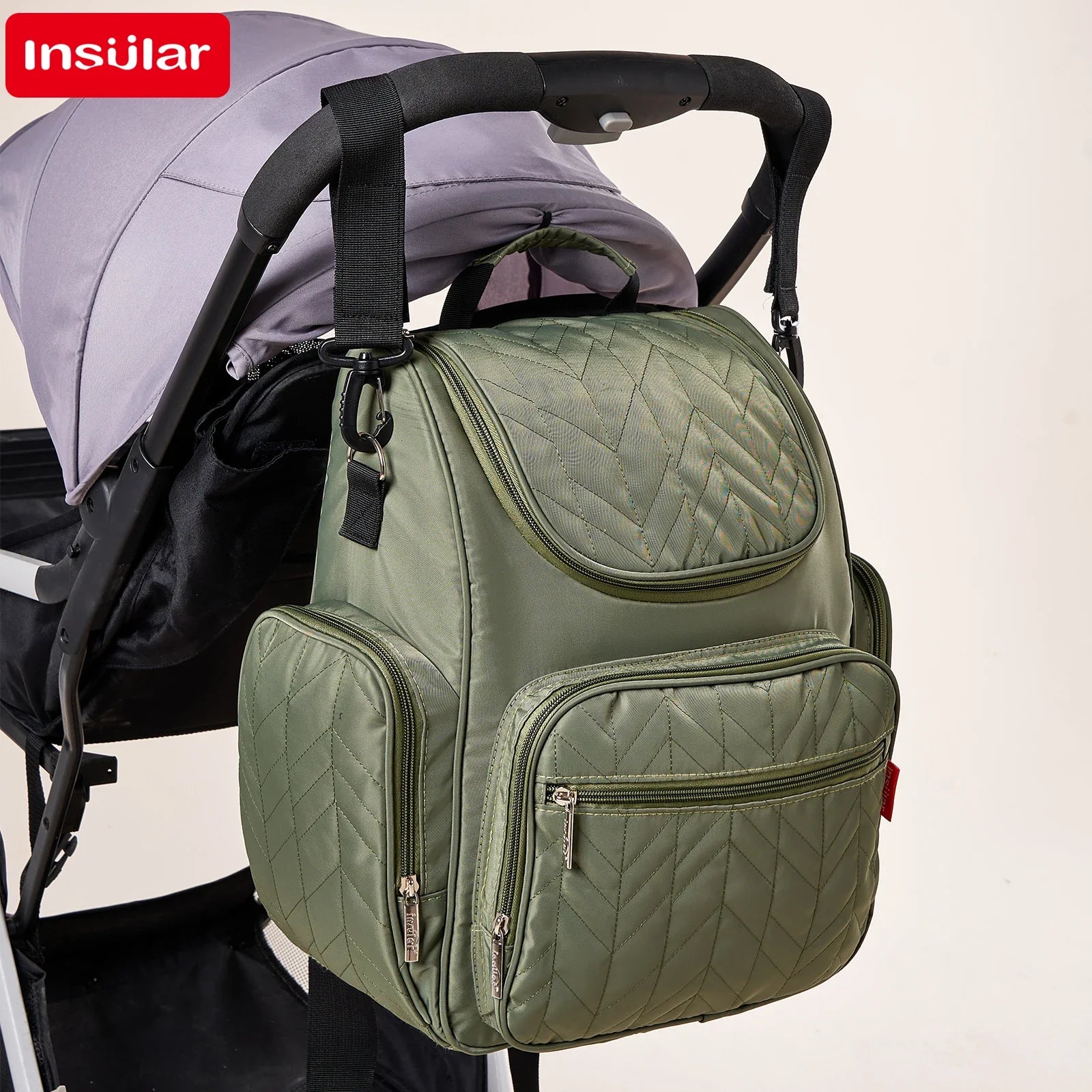 Sac a langer accroche a la poignee de la poussette, liberant les mains lors des balades.