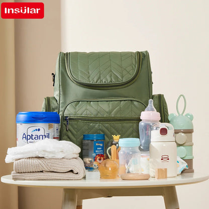 Sac a langer entoure de biberons, lait et accessoires bebe montrant tout ce qu'il peut contenir.