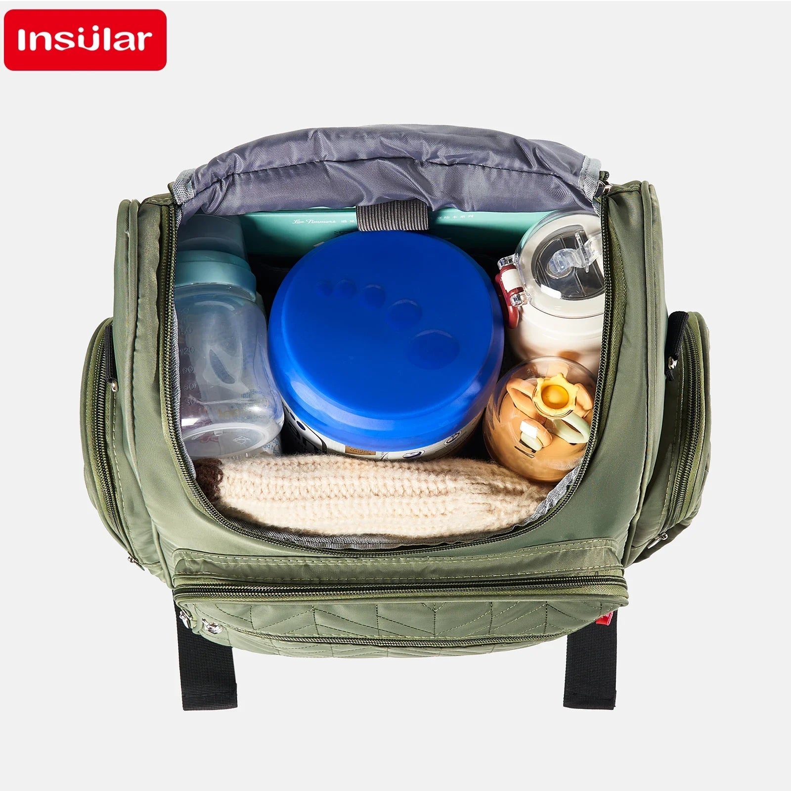 Interieur spacieux du sac ouvert accueillant biberons, boite de lait et vetements pour une journee entiere.