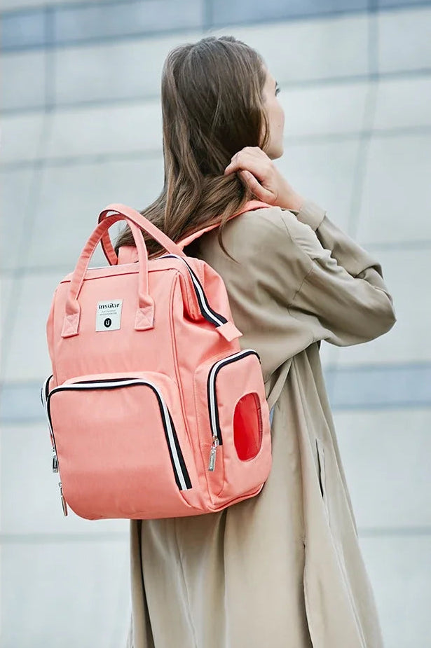 Le sac a langer porte en mode decontracte, prouvant qu'il ressemble a un sac a dos mode plutot qu'a un accessoire bebe.