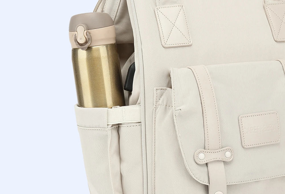 Poche laterale extensible du sac a langer maintenant un biberon isotherme accessible en un instant.