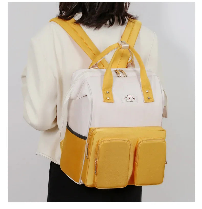Porte sur le dos, le sac a langer libere les mains des parents pour s'occuper de bebe en toute serenite.