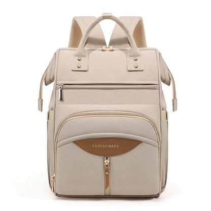 Sac a langer a dos coloris beige avec details dores et cuir, un accessoire chic et pratique pour les sorties avec bebe