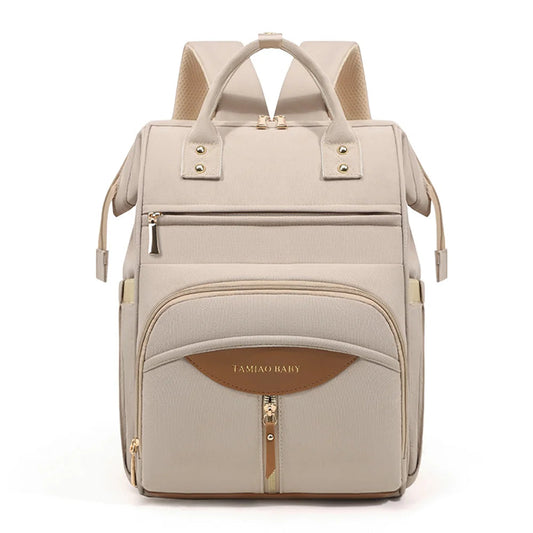 Sac a langer a dos coloris beige avec details dores et cuir, un accessoire chic et pratique pour les sorties avec bebe