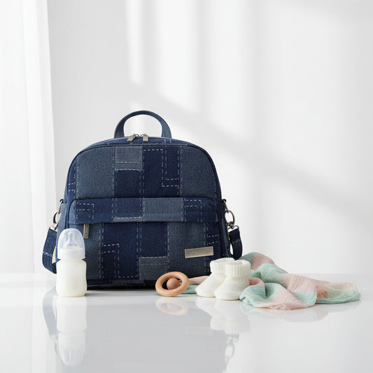 Sac a langer sac a dos en denim bleu marine avec motif patchwork, ideal pour les parents qui veulent allier style et praticite en promenade.