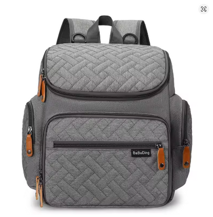 Sac a langer sac a dos gris matelasse au design elegant et unisexe, ideal pour les parents en deplacement.