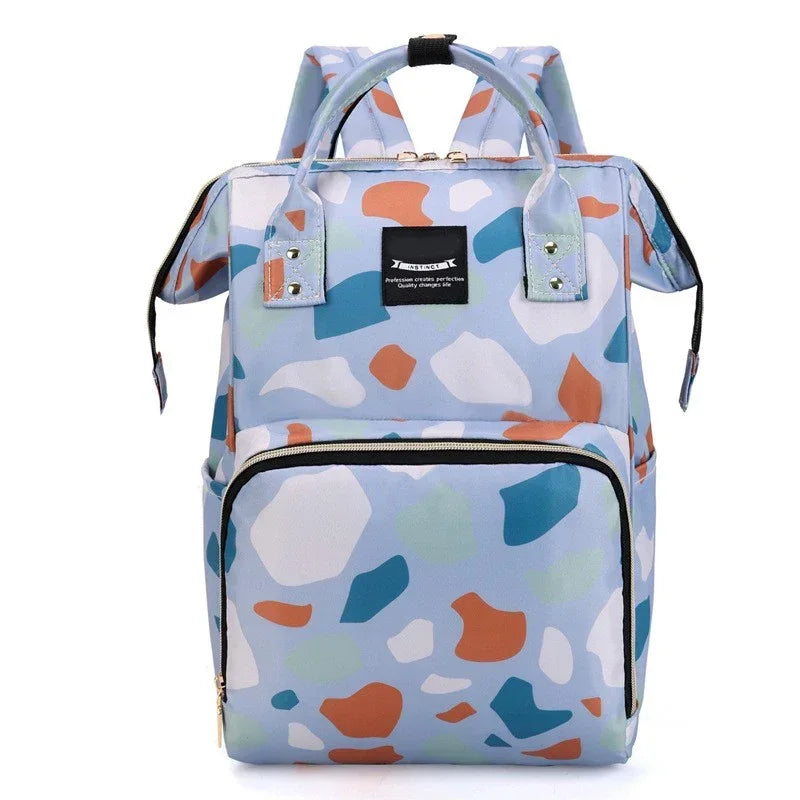 Sac a langer sac a dos au motif terrazzo bleu avec grande poche zippee frontale, ideal pour transporter les affaires de bebe avec style.