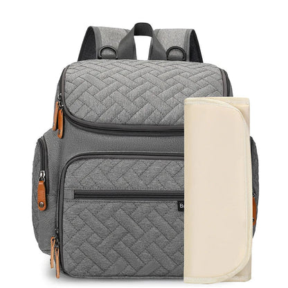 Sac a dos a langer gris livre avec son tapis a langer nomade pour changer bebe partout en toute hygiene.