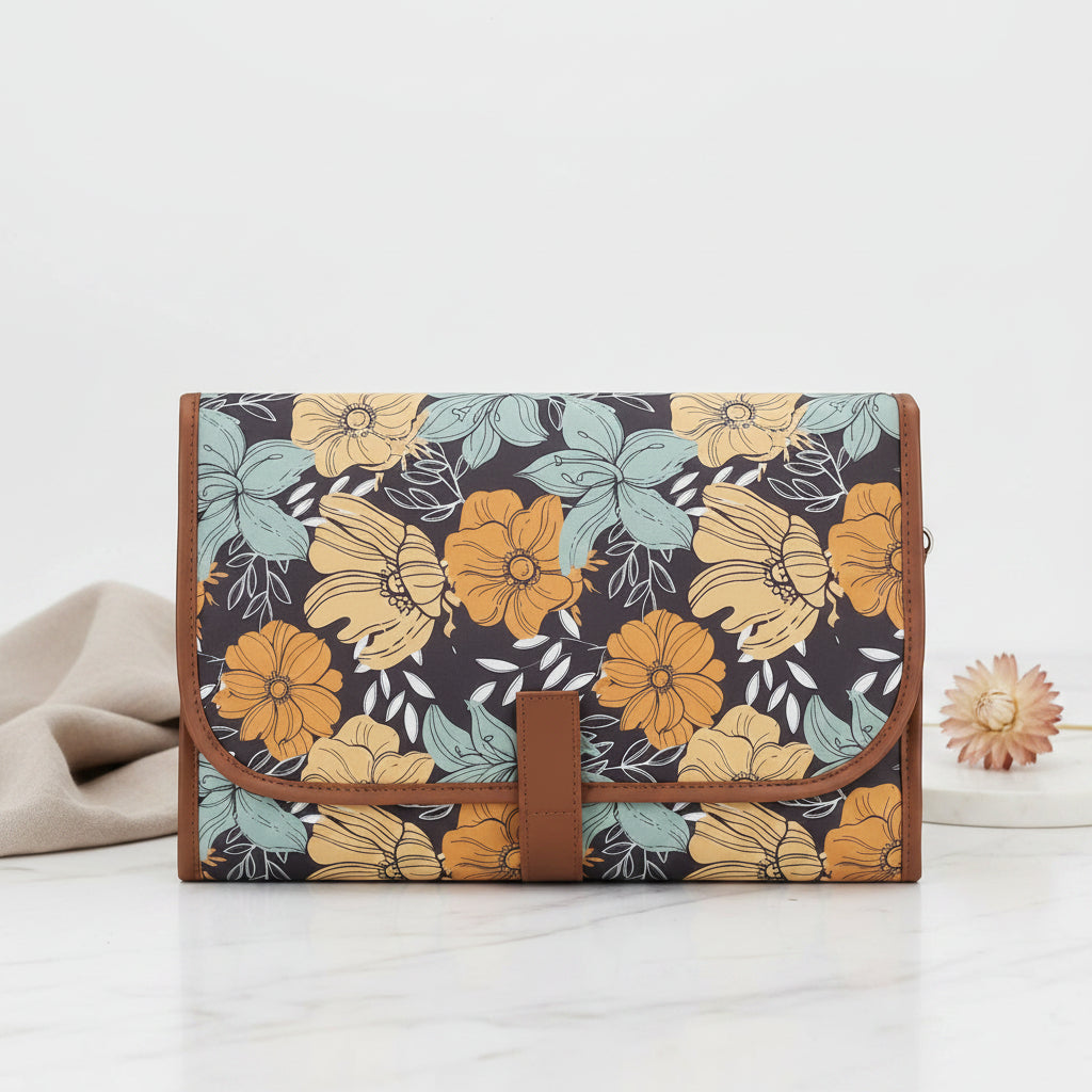 Tapis a langer nomade plie dans un motif floral aux tons chauds ocre et vert, compact et facile a ranger.