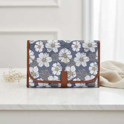 Tapis a langer de voyage plie dans un imprime floral bleu gris raffine, pratique a emporter partout pour changer bebe.