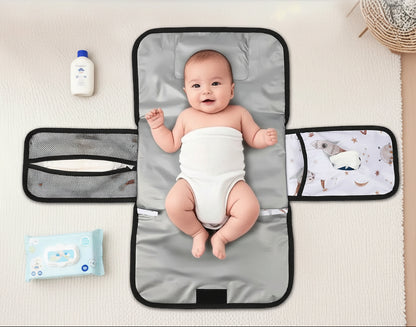 Bebe installe confortablement sur le tapis a langer deploye, calant sa tete sur le coussinet integre pendant le change.