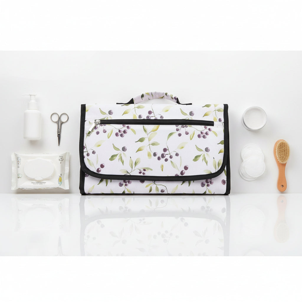 Pochette a langer refermee au motif baies et feuillage doux, format sacoche facile a transporter en sac a main.