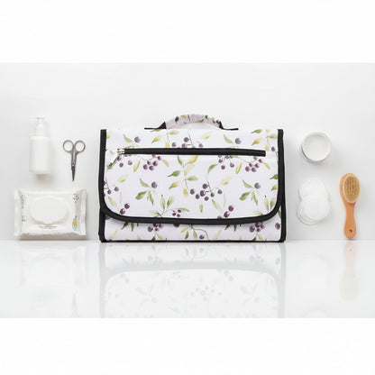 Pochette a langer refermee au motif baies et feuillage doux, format sacoche facile a transporter en sac a main.