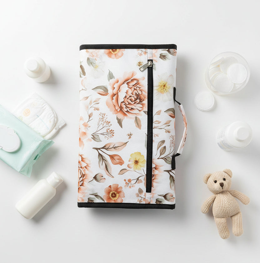 Tapis a langer nomade plie et refermable au motif floral elegant, se glisse discretement dans le sac a langer.