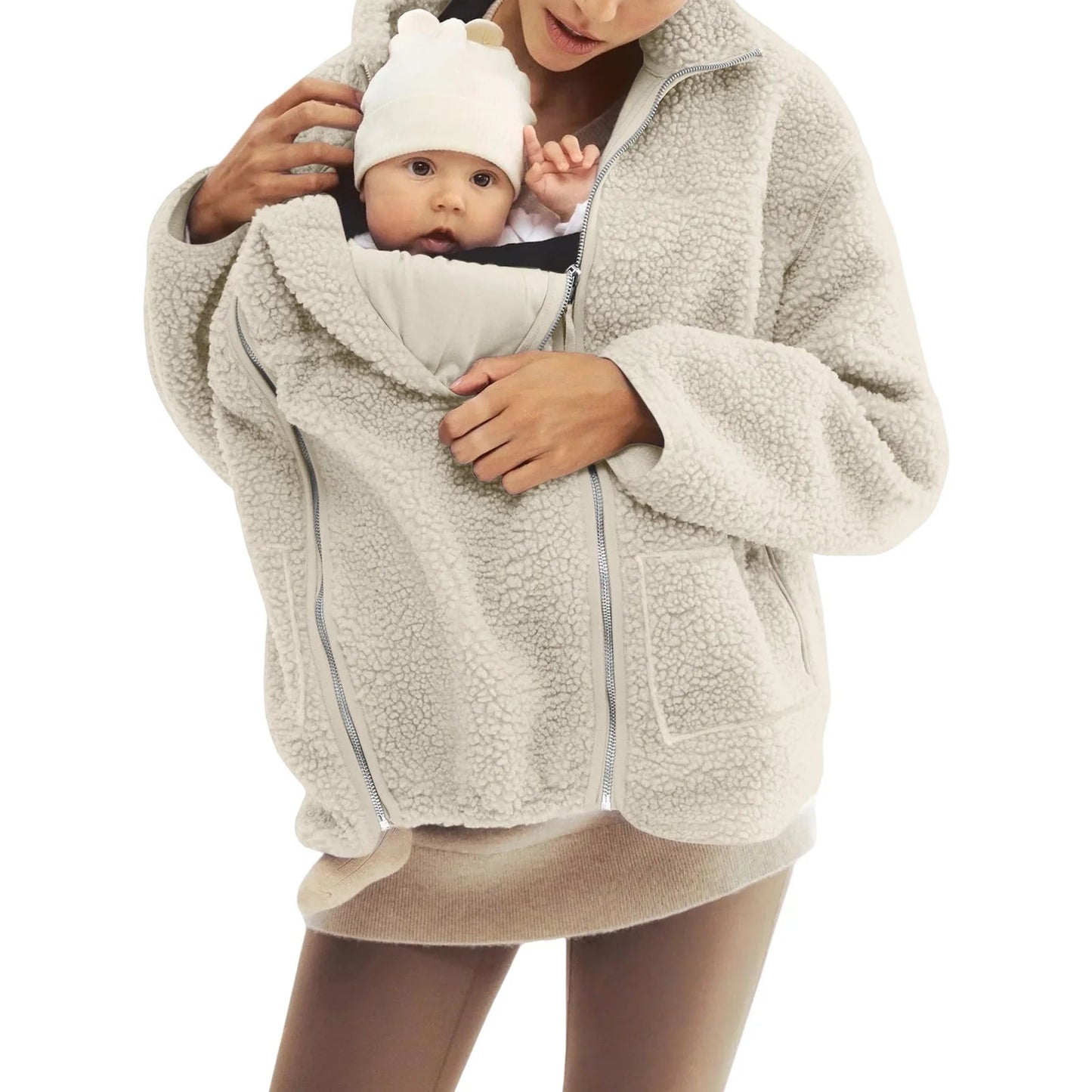 Maman portant son bebe blotti dans la poche kangourou de la veste beige, le tout-petit reste au chaud contre elle pendant la promenade.